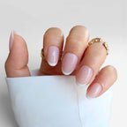 minimal white french tip. short nails. salon quality premier press ons new zealandLa Parisienne nail design featuring a natural pink base with white tips, hand adorned with gold rings on a white background.