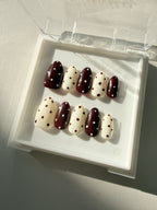 Close up of Choco Dots hand-painted polka dot press on nails