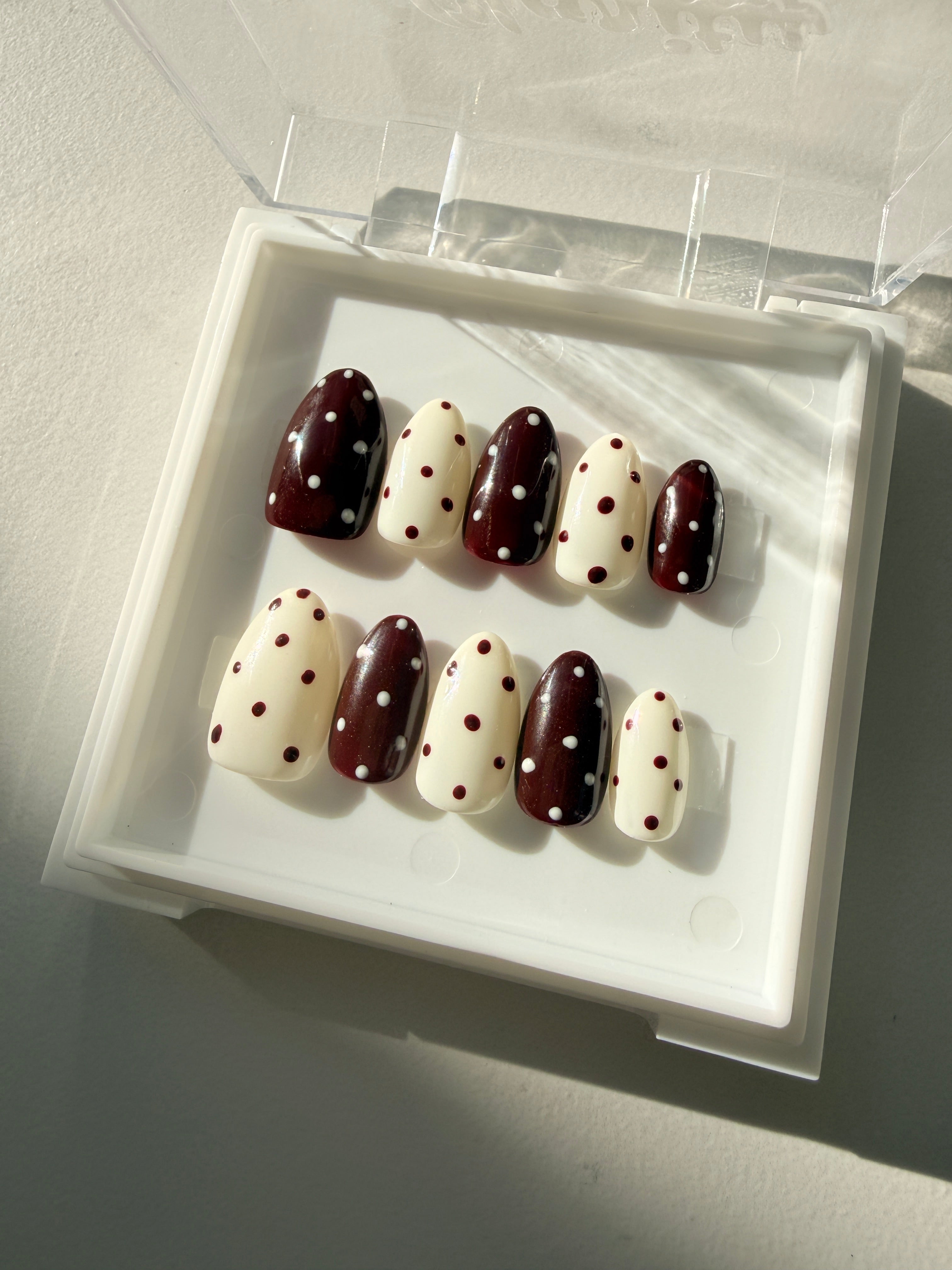 Close up of Choco Dots hand-painted polka dot press on nails